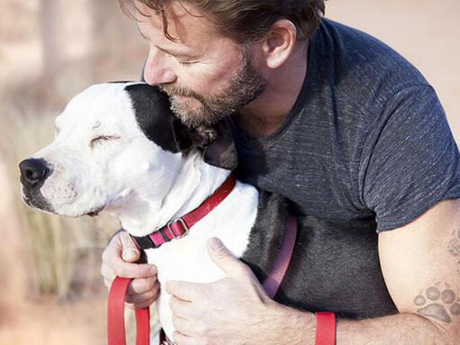 Man cuddling dog