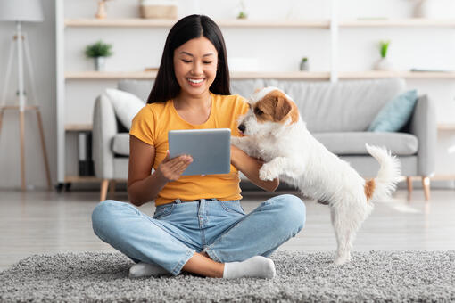 girl and dog looking at ipad